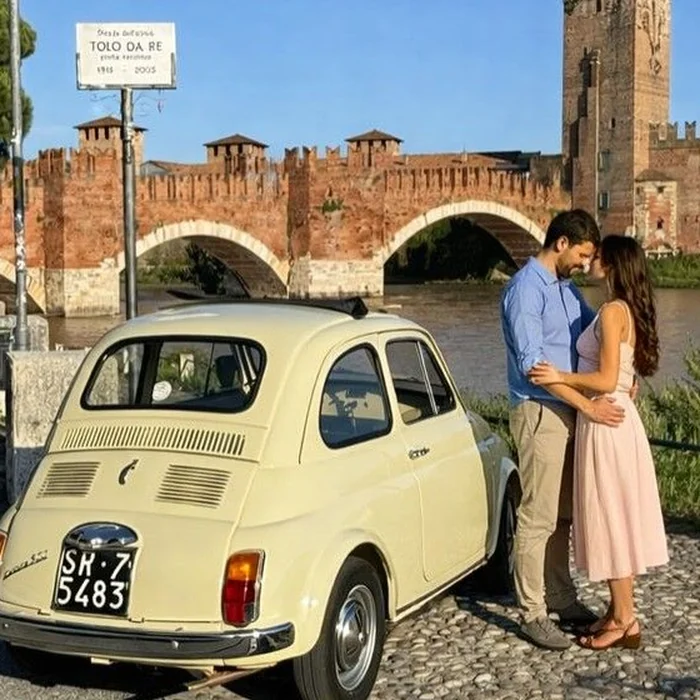 Una coppia accanto a una Fiat 500 crema, davanti al ponte di Castelvecchio a Verona
